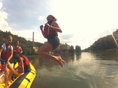 Studerende padle på en flod med kajakker, flåder og kanoer - skoletur til Tjekkiet. En dags eventyr fra Prag.