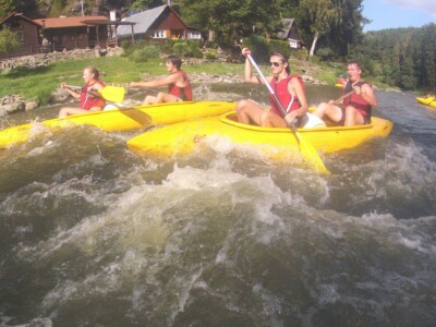 Studerende padle på en flod med kajakker, flåder og kanoer - skoletur til Tjekkiet. En dags eventyr fra Prag.