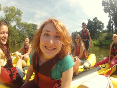Studerende padle på en flod med kajakker, flåder og kanoer - skoletur til Tjekkiet. En dags eventyr fra Prag.