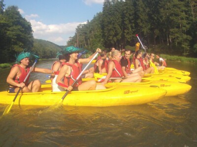Studerende padle på en flod med kajakker, flåder og kanoer - skoletur til Tjekkiet. En dags eventyr fra Prag.