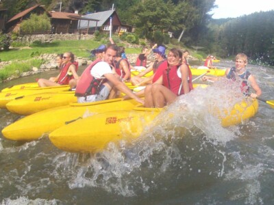 Studerende padle på en flod med kajakker, flåder og kanoer - skoletur til Tjekkiet. En dags eventyr fra Prag.