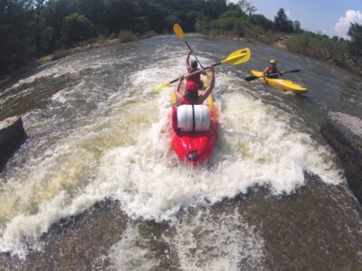 Studerende padle på en flod med kajakker, flåder og kanoer - skoletur til Tjekkiet. En dags eventyr fra Prag.