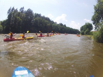 Studerende padle på en flod med kajakker, flåder og kanoer - skoletur til Tjekkiet. En dags eventyr fra Prag.