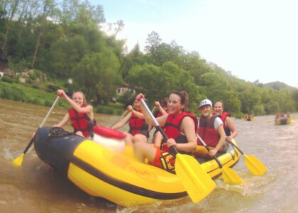 Studerende padle på en flod med kajakker, flåder og kanoer - skoletur til Tjekkiet. En dags eventyr fra Prag.